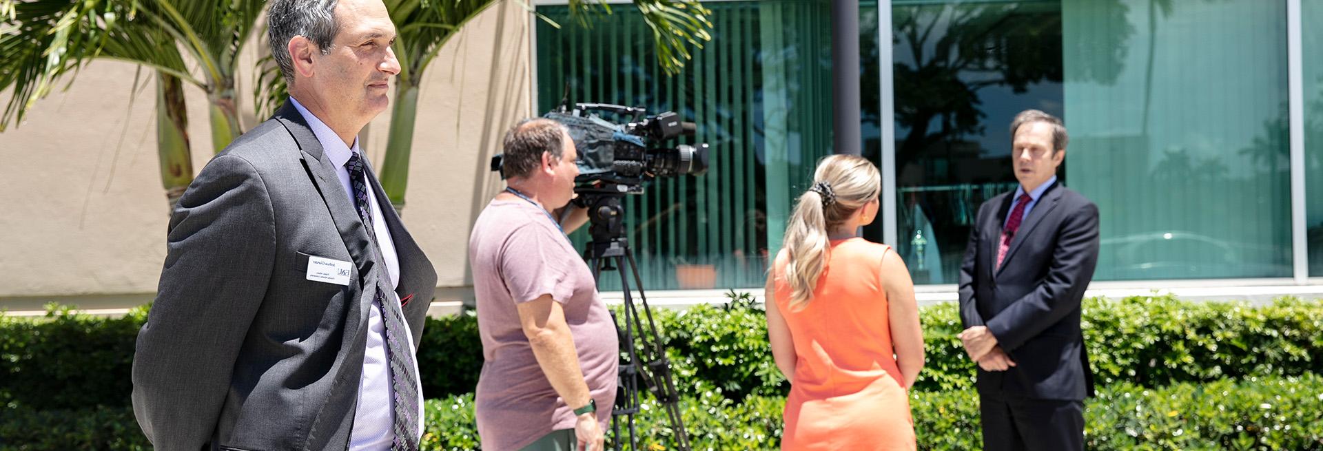 Media relations overseeing a news interview with the university president